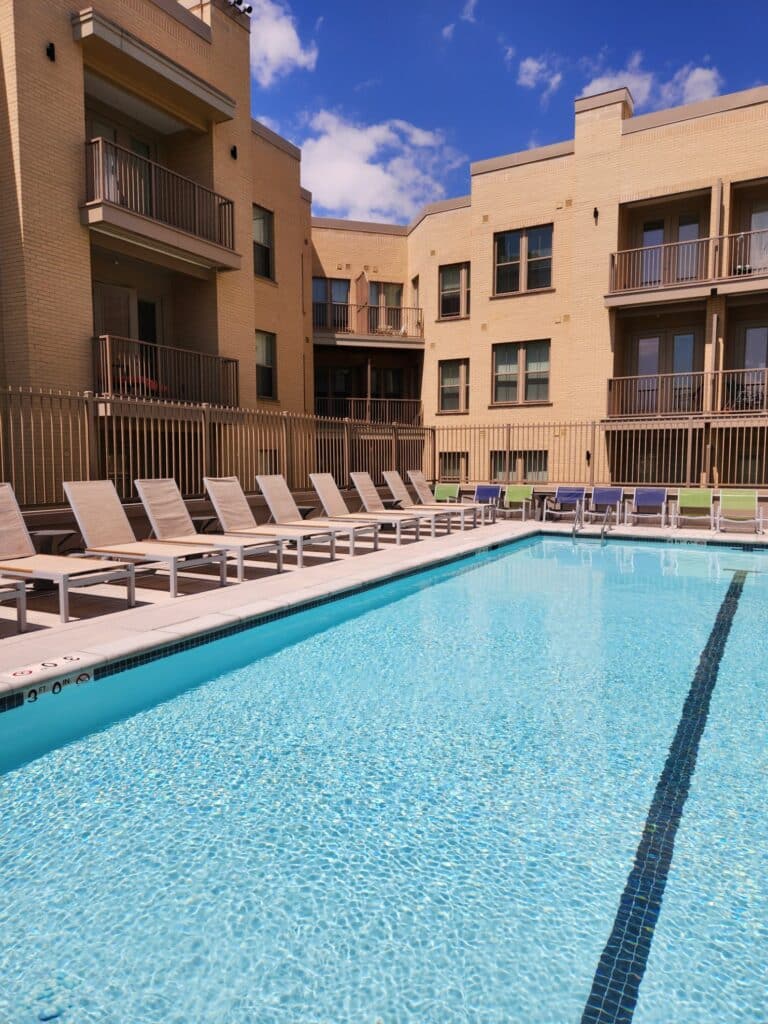swimming pool with lounge chairs and apartments in the background at crest apartments in washington dc
