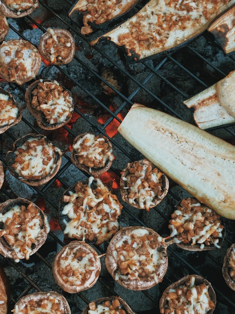 Top view appetizing stuffed mushrooms and ripe cut eggplants roasting grill