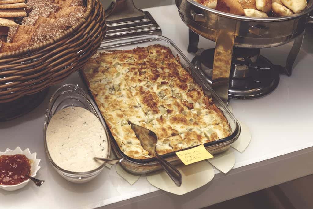 A mouth-watering baked casserole served with bread and sauce, perfect for a cozy dinner.