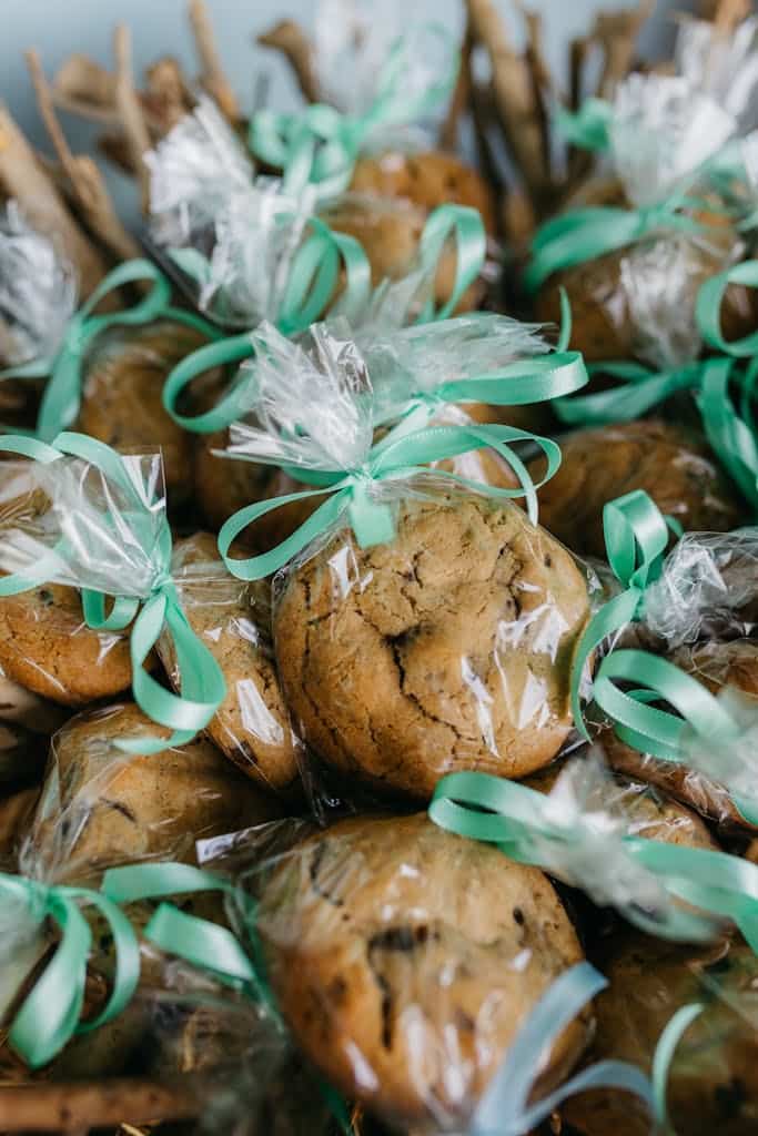 Close-up of freshly baked cookies wrapped in transparent bags with green ribbons.