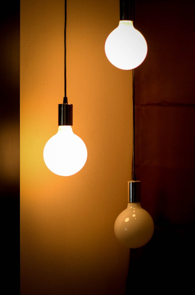 Composition of three glowing light bulbs creating a warm ambiance. Ideal for energy and design themes.