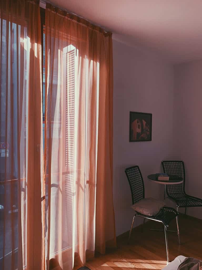 Sunlit room with modern chairs, table, curtains in Regensburg, Germany.