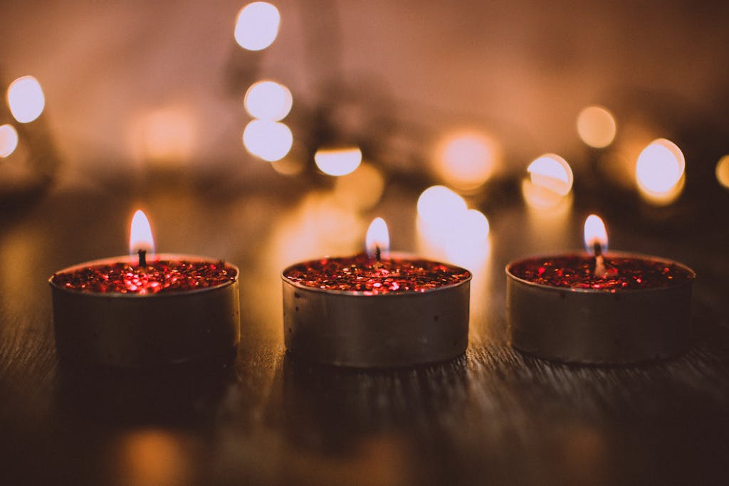 Three red glittery candles burning warmly, evoking a cozy ambiance perfect for celebrations.